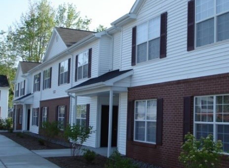 Exterior of apartment units next to a sidewalk